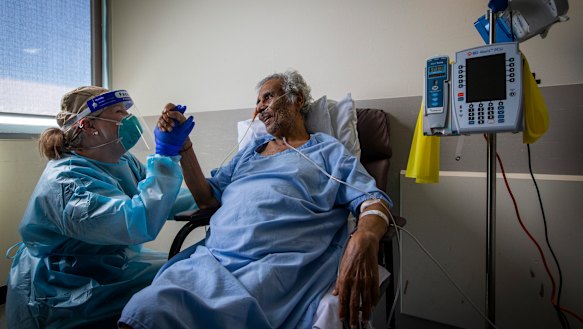 COVID 19 survivor Viswanathan Nair and ICU physiotherapist Kimberley Haines at Footscray Hospital. He faces an uphill battle as he learns to walk on his own again.