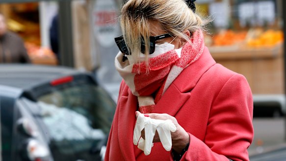 A Frenchwoman queues outside a pharmacy as new laws come into place.