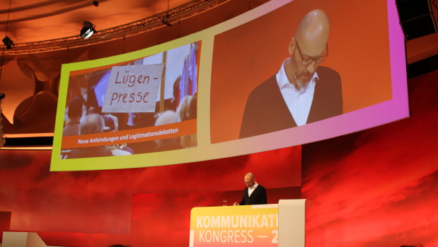 Steffen Klusmann, editor-in-chief of news magazine Der Spiegel, presents at a media conference in Berlin. The Nazi-era term for "lying press" is displayed behind him. 