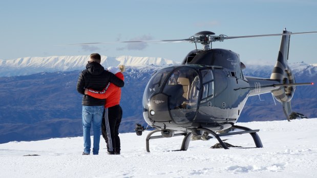 Tourists enjoy one of the spectacular views on offer from one of the mountains surrounding Queenstown, New Zealand.