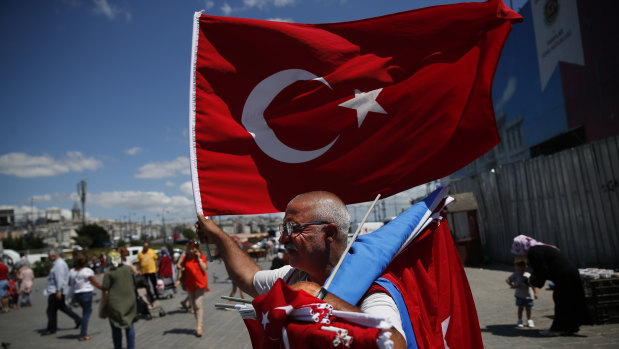 A vendor offers Turkish flags for sale at a market in Istanbul on Monday.