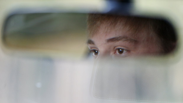 Charlie Shebes, 16, a junior at Marjory Stoneman Douglas High School, is reflected in his rear view mirror as he drives to school.