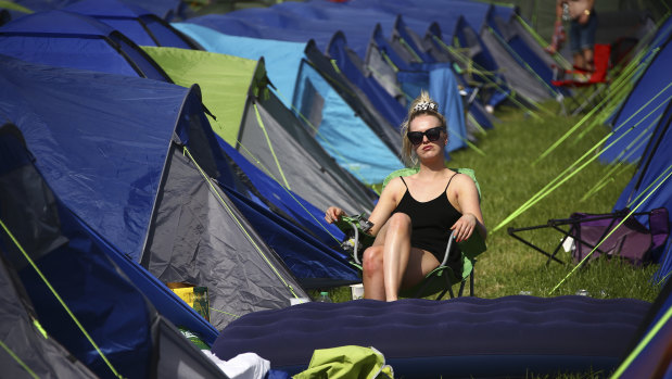 A festivalgoer sits in the sunshine amongst tents at the Glastonbury Festival in England on Friday.