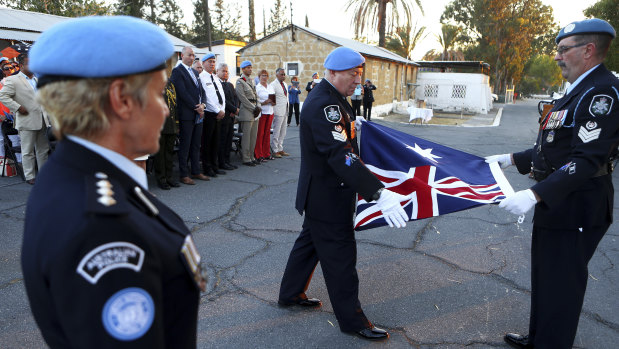 Australian U.N police officer fold the Australian flag during a flag-lowering ceremony to ended Australia's peacekeeping contribution in Cyprus in Nicosia in 2017.