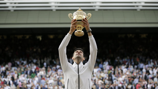 Novak Djokovic lifts the trophy after defeating Switzerland's Roger Federer at Wimbledon in 2019