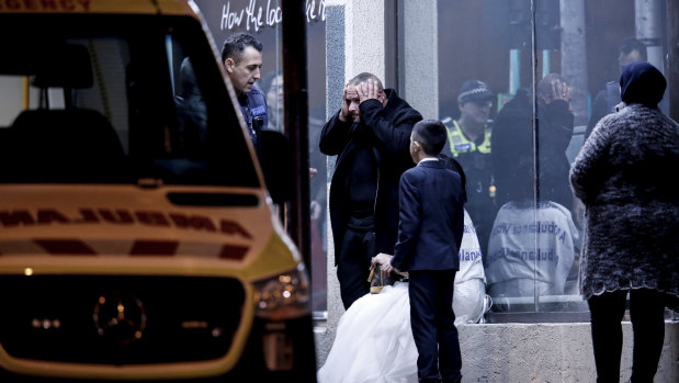 A woman in a bridal gown and a young boy outside the venue.