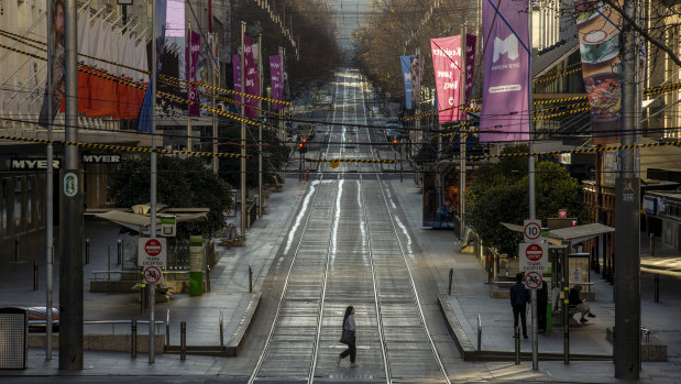 A lone pedestrian crosses an empty Bourke Street in Melbourne's CBD on Sunday morning. 