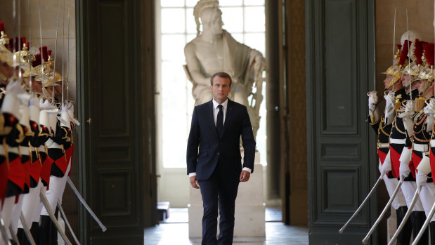 French President Emmanuel Macron walks to address both the upper and lower houses of the French Parliament at a special session at Versailles on Monday.