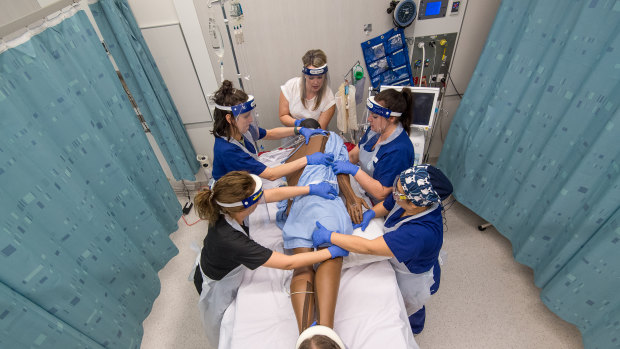 Dr Kimberley Haines leads a team of physio and other health workers turning a dummy patient in simulation training.