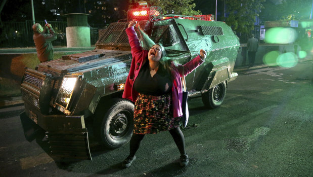 A woman shouts protests near the Santa Lucia subway station in Santiago during a protest against the rising cost of public transport fares.