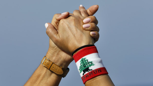 Thousands of Lebanese have formed a human chain along highways and coastal roads to link Beirut and other cities in a show of solidarity with the anti-government protests.