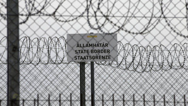 A sign reading: “State Border” is attached to a fence at Hungary’s border with Serbia near the village Asotthalom, Hungary.