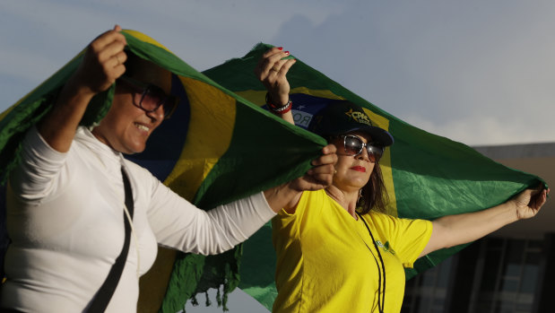 Supporters of Brazil's President Jair Bolsonaro hold Brazilian national flags outside the Supreme Court on Thursday.