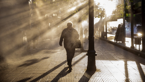 A pedestrian walks through tear gas during a protest in Santiago on Friday.