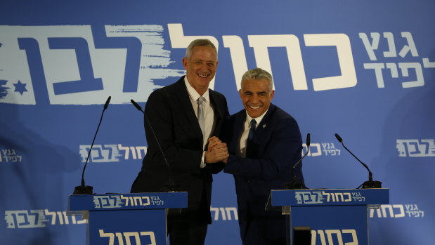 Retired Israeli military chief Benny Gantz, left, smiles with Yair Lapid, head of the Yesh Atid party.