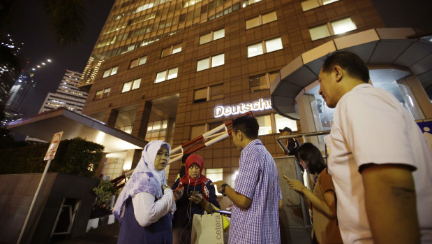 People gather as they evacuate from a building after a strong earthquake.