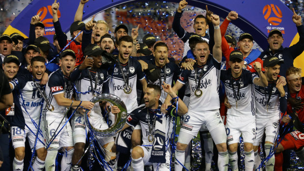 Victory celebrate with the A-League trophy.