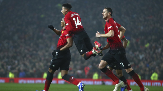 Manchester United's Jesse Lingard jumps on the shoulders of teammate Anthony Martial, after he scored against Arsenal.