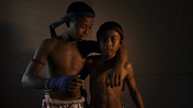 Muay Thai fighters and brothers Pet Phuton,14 (left) and Ek Phuton, 12, wearing the traditional Muay Thai headband called a Mongkon at Nor Naksin Muay Thai camp where they train.