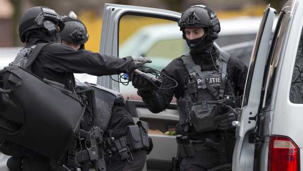 Counter terrorism police prepare to enter a house after the shooting incident.