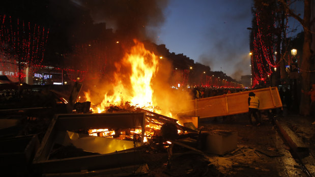 Demonstrators set up a burning barricade on the Champs-Elysees avenue during a demonstration against the rising of the fuel taxes on Saturday.