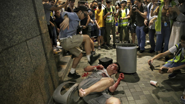 A man hits a suspected attacker after an incident broke out outside a Hong Kong mall.