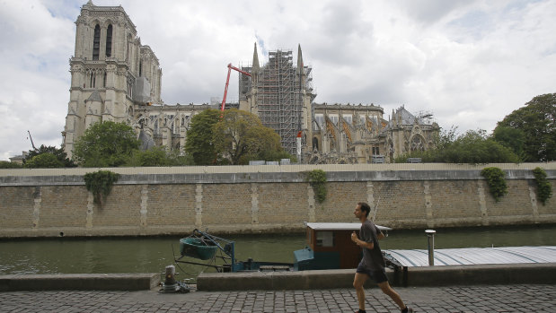A man jogs along the Seine River near Notre-Dame.