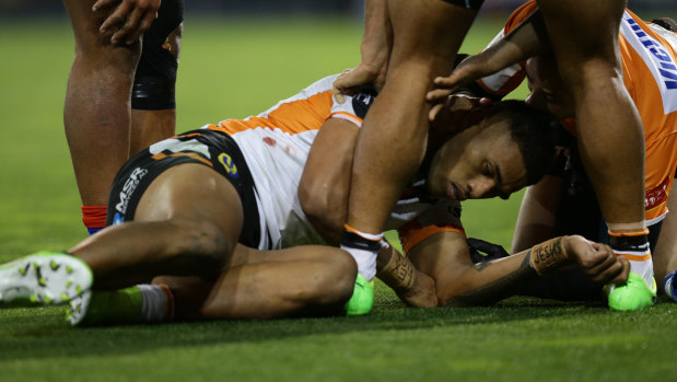 Nasty blow: Michael Chee Kam on the deck after the collision with Kalyn Ponga.