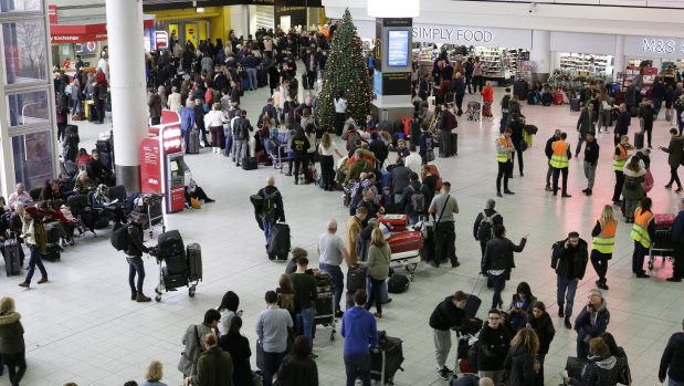 People queue at Gatwick airport, near London on Thursday.