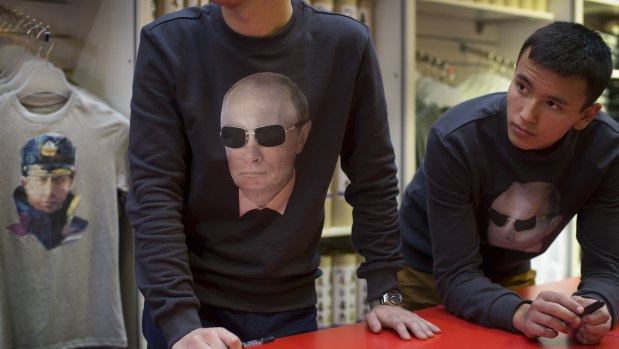 Putin, pictured on souvenir t-shirts, is the country's brand, analysts say.