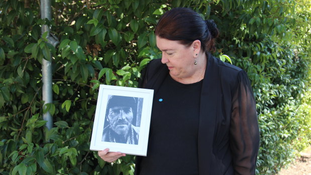 Mark Russell's sister Julie Ann Stewart looks at a photo of him outside the NSW Coroners Court.