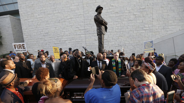 Demonstrators march around AT&T Stadium ahead of an NFL football game between the Dallas Cowboys and the New York Giants in protest of the recent killings of two black men by police, in Arlington, Texas.