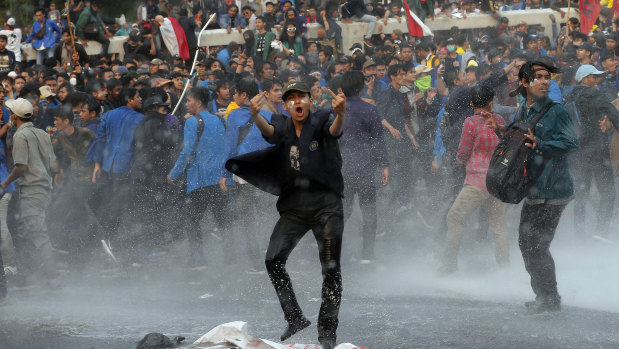 Student protesters shout slogans agaisnt the changes to the penal code during clashes outside Parliament in Jakarta, Indonesia, on Tuesday.