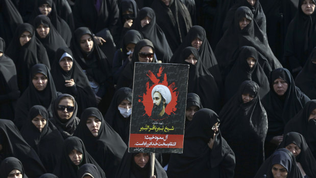 An Iranian woman holds up a poster showing Sheikh Nimr al-Nimr, a prominent opposition Saudi Shiite cleric who was executed by Saudi Arabia, in Tehran, Iran, in 2016.