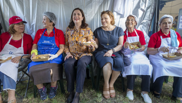 Queensland Premier Annastacia Palaszczuk (centre) and Queensland Deputy Premier Jackie Trad are seen sitting with cooks at the Greek Paniyiri Festival in Brisbane.