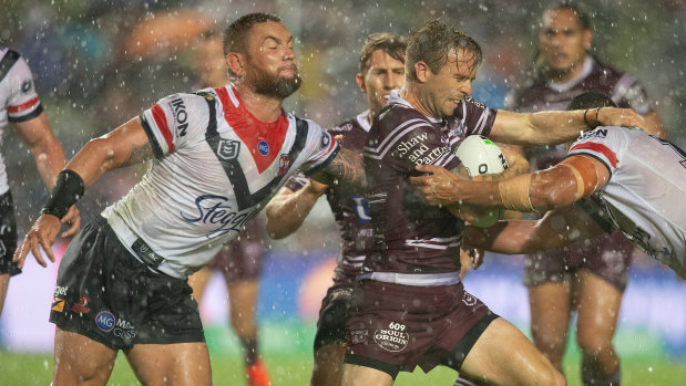 Downpour: Manly's Kane Elgey is tackled in the big wet.