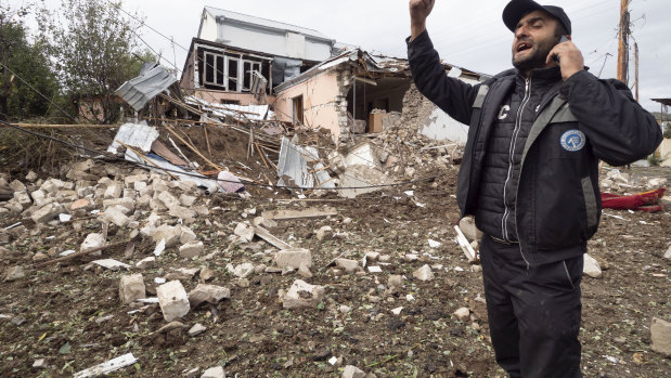 A man speaks on the phone near a house destroyed by shelling by Azerbaijan's artillery in Stepanakert, self-proclaimed Republic of Nagorno-Karabakh.