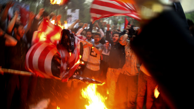 Iranian demonstrators burn representations of the US flag during a protest in front of the former US Embassy in response to President Donald Trump's decision Tuesday to pull out of the nuclear deal and renew sanctions, in Tehran, Iran. 