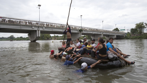 A group of Central American migrants cross the Suchiate River on the the border between Guatemala and Mexico, in Ciudad Hidalgo. Others attempted to swim across.