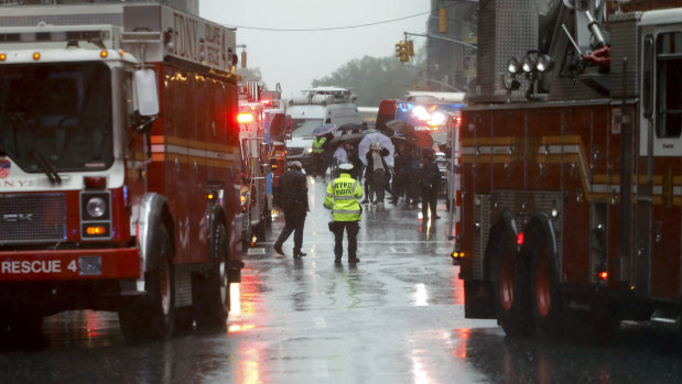 First responders arrive near the scene where a helicopter crash-landed on the roof a midtown Manhattan skyscraper.