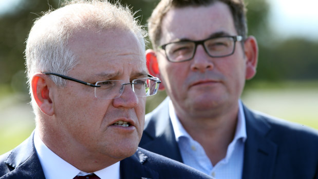 Prime Minister Scott Morrison speaks to the media while Victorian Premier Daniel Andrews looks on .