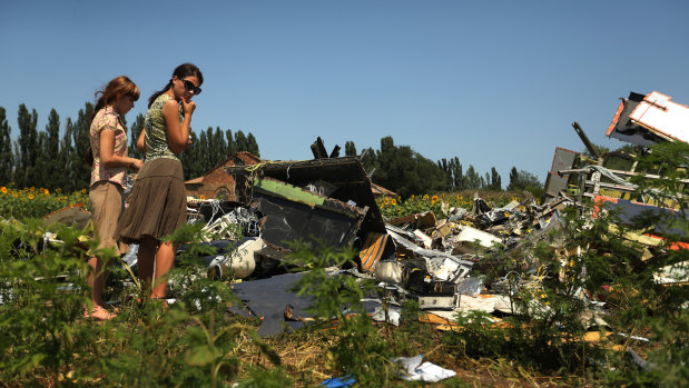 Women look at the debris of downed Malaysian flight MH17 cockpit site on the outskirts of Rassypnoye village in the self proclaimed Donetsk People's Republic, East Ukraine.