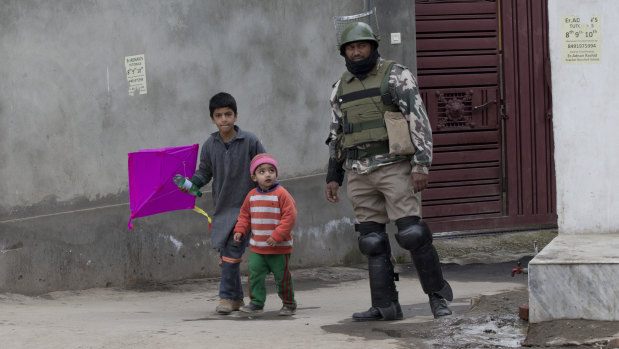 Kashmiri children walk past an Indian paramilitary soldier in Srinagar, Indian-controlled Kashmir.