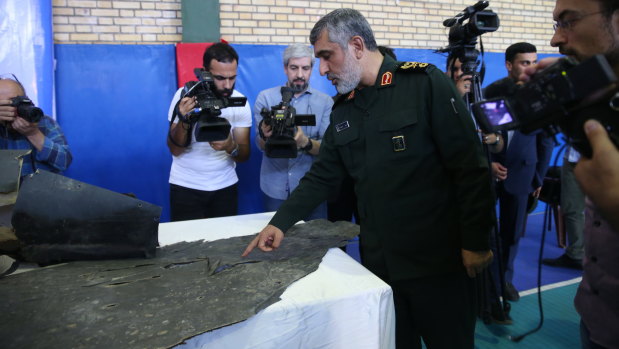 Head of the Revolutionary Guard's aerospace division General Amir Ali Hajizadeh points at the wreckage of US drone RQ-4A in Tehran.