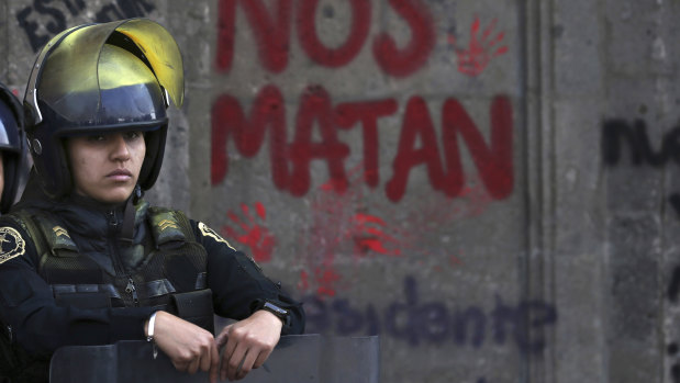 A guard outside the National Palace, the presidential office and residence, during a demonstration against gender violence in Mexico City.