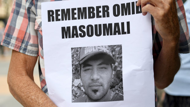 A photograph of Omid Masoumali is held outside the Brisbane Magistrates Court in Brisbane.