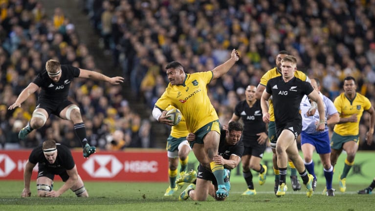 Tough night at the office: Polota-Nau is tackled by Anton Lienert-Brown during the Wallabies' heavy defeat on Saturday night.