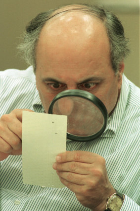 Judge Robert Rosenberg of Broward County Canvassing Board uses a magnifying glass to view a dimpled chad (the bit of paper pushed out when a hole is punched) on a punch-hole ballot in 2000, during a recount of votes in Fort Lauderdale, Florida. 
