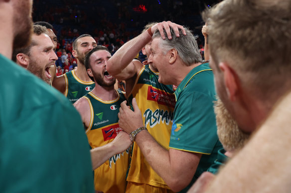 Tasmania JackJumpers players celebrate their semi-final win over Perth with coach Scott Roth.