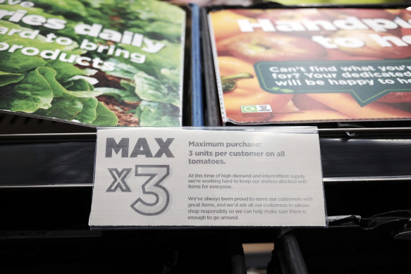 A “Max 3 units” sign is attached to empty fruit and vegetable shelves at an Asda in east London.